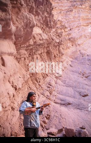 Musicien local jouant du charango et de la flûte pan à l'intérieur de l'amphithéâtre de la Quebrada de las Conchas à Salta, au nord-ouest de l'Argentine. Banque D'Images