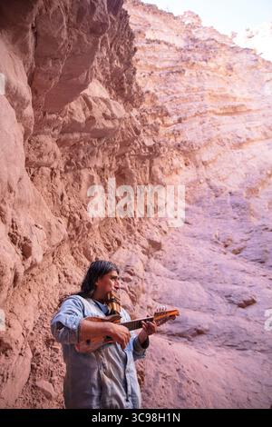 Musicien local jouant du charango et de la flûte pan à l'intérieur de l'amphithéâtre de la Quebrada de las Conchas à Salta, au nord-ouest de l'Argentine. Banque D'Images