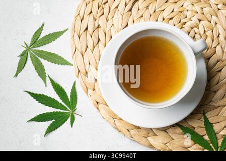 Tisane de chanvre et feuilles de chanvre vert, vue de dessus. Boisson calmante naturelle pour un sommeil sain. Banque D'Images