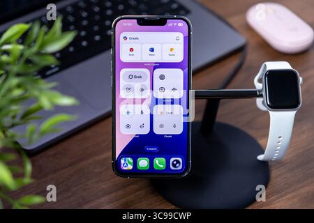 Poznan, Pologne - 29 juillet 2025 : une station de travail organisée est équipée d'un iPhone avec CoPilot M365, incarnant les concepts de verre liquide ios 26 Banque D'Images