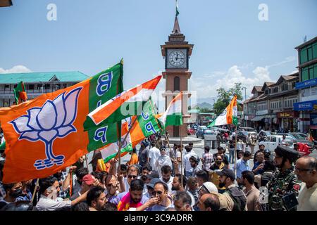 Srinagar, Inde. 05 août 2025. Les partisans du Bharatiya Janata Party (BJP) tiennent leurs drapeaux de parti alors qu'ils célèbrent le sixième anniversaire de l'abrogation de l'article 370 et du statut spécial du Jammu-et-Cachemire au centre-ville de Lal Chowk. Le gouvernement du premier ministre indien Narendra Modi a abrogé l'article 370 le 5 août 2019, mettant fin au statut spécial semi-autonome de la région. Crédit : SOPA images Limited/Alamy Live News Banque D'Images