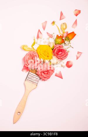 Pinceau et fleurs fraîches sur un fond rose avec espace de copie. Art minimal créatif Banque D'Images