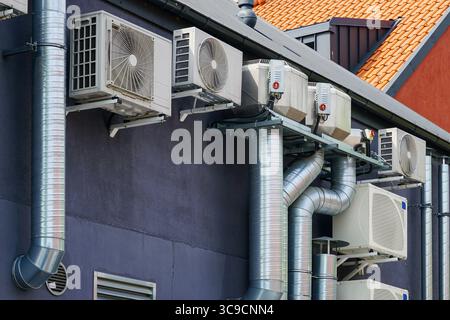 Une vue détaillée des climatiseurs HVAC et des grands conduits de ventilation installés sur le côté d'un bâtiment commercial Banque D'Images