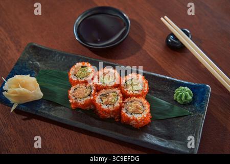 Une assiette de Sushi Rolls préparée avec art mettant en valeur les ingrédients frais avec des accompagnements de wasabi, de gingembre mariné et de sauce soja pour un exquis Banque D'Images