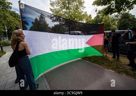 Les militants bloquent le trottoir avec un grand drapeau palestinien pendant la manifestation. Dans l'après-midi du 5 août, la veille de la prestation de serment du nouveau président polonais, des militants pro-palestiniens ont bloqué la route devant la Chancellerie du premier ministre polonais à Varsovie. Les manifestants appellent à la fin de la coopération du gouvernement avec le gouvernement sioniste de droite d'Israël. Les manifestants ont bloqué la route avec une banderole et des fusées éclairantes avant que la police ne les emmène sur le bord de la route, où la manifestation a continué. Banque D'Images