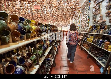 Raquira, Boyaca, Colombie ; 29 novembre 2022 : femme marchant dans une allée d'un magasin de souvenirs et d'artisanat en céramique Banque D'Images