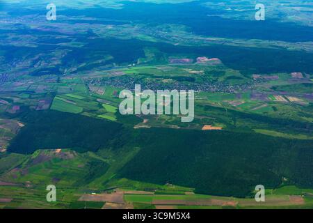 Les champs verdoyants et les forêts créent une vue magnifique du paysage d'en haut. Patchwork de champs verts et de forêts, parsemé de petits villages, s'étire Banque D'Images