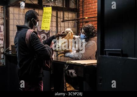 19 décembre 2020, Paris 20ème arrondissement (20ème Arrond, Ile-de-France (région, France) : un volontaire donne un sac avec une entrée, un plat et un dessert. Les bénéficiaires peuvent avoir droit à deux repas. La flèche d'Or solidaire n'exige aucune preuve personnelle de statut social. La flèche d'Or rouvre ses portes pour devenir un lieu socioculturel au service du quartier et des luttes sociales. (Crédit image : © Sadak Souici/ZUMA Press Wire) Banque D'Images