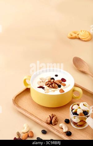 Délicieux et sain bol de noix et graines mélangées avec yaourt et friandises, petit déjeuner sain avec muesli, noix et brioches. Banque D'Images