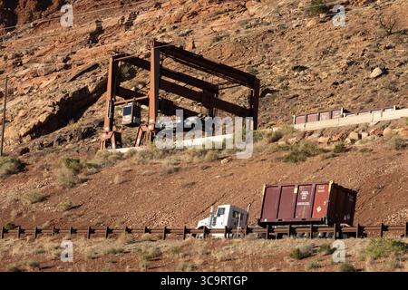 Le 31 octobre 2022, Moab, Utah, États-Unis : un camion approche le manutentionnaire de conteneurs pour charger des conteneurs de déchets scellés au projet de taillage de l'usine radioactive UMTRA, Moab, Utah. Le manipulateur de conteneurs roulants enlève des camions des conteneurs scellés de résidus radioactifs de minerai d'uranioum et les charge sur des wagons pour les transférer au site de dépôt lorsque le train revient avec des conteneurs vides, le manipulateur de conteneurs les enlève des wagons et les place sur les camions. Le manipulateur de fret roule le long des voies lorsqu'il charge et décharge les wagons. (Crédit image : © Jon G. Full Banque D'Images