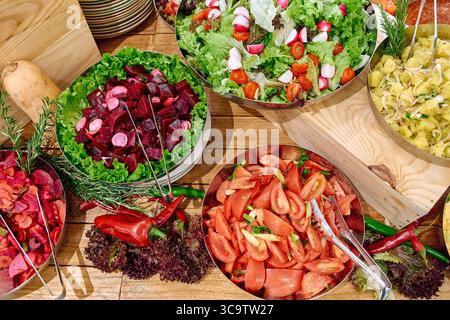 Un affichage coloré de salades fraîchement préparées avec des légumes et des verts vibrants, parfait pour une cuisine nutritive et des choix de mode de vie sains Banque D'Images