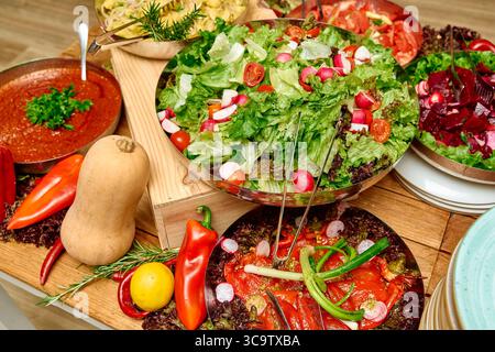 Un vif affichage de salades fraîchement préparées avec une variété de verts, légumes colorés et vinaigrettes savoureuses disposées magnifiquement sur un Woo Banque D'Images