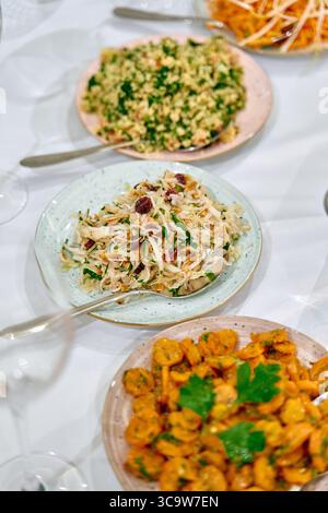 Un affichage coloré de salades fraîchement préparées et de plats de fruits de mer sur des assiettes élégantes, mettant en valeur l'art culinaire gastronomique et les ingrédients vibrants pour un Banque D'Images