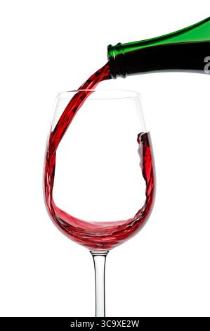 Vin rouge versé dans un verre sur fond blanc, gros plan Banque D'Images