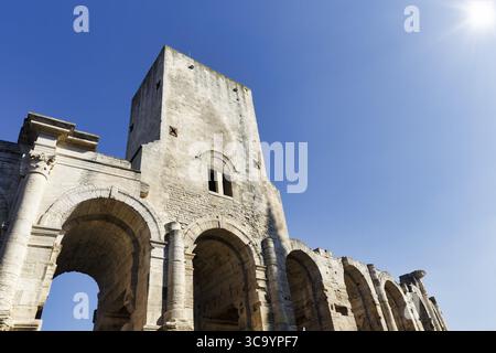 Amphithéâtre romain devant un ciel bleu, rayons de soleil, Arles, Provence, France Banque D'Images