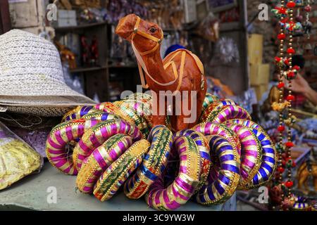 Pushkar Mela, Pushkar, Grand chameau et marché au bétail, Rajasthan, Inde du Nord, Asie, Un stand de souvenirs avec un chameau décoratif et des bracelets colorés, in Banque D'Images
