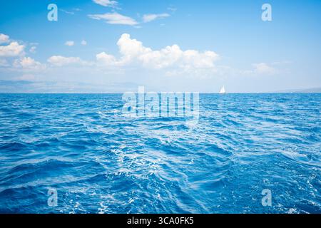 Petit yacht à voile à l'horizon sous ciel dégagé dans la mer Adriatique près de la Croatie. Minimalisme, liberté, solitude et déplacements lents sur l'eau libre. Banque D'Images