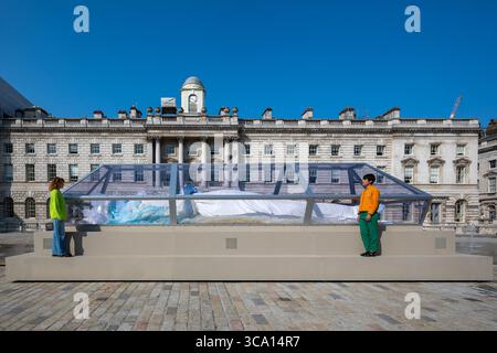 Londres, Royaume-Uni, 6 août 2025, Tai Shani : le sort ou le rêve à Somerset House. Il sera dévoilé le 8 août au public, célébrant le 25e anniversaire de Somerset House. Cette nouvelle œuvre d'art public ambitieuse comprend une figure sculpturale brillante reposant dans une vitrine semblable à du verre. L'installation comprend également une station de radio numérique 24/7, des cabines d'écoute et un programme estival d'événements en direct créé pour Andrew Lalchan Photography/Alamy Live News Banque D'Images