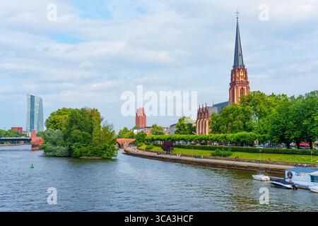Francfort, Allemagne - 10 juin 2025 : vue panoramique de la cathédrale impériale de Saint-Barthélemy entourée d'une végétation luxuriante et de la rivière Banque D'Images