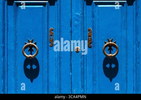 Détail de l'entrée double porte d'une maison à la Valette, Malte. Double frappeur de porte avec croix maltaise. Peint en bleu avec serrure à clé et détails en métal. Banque D'Images