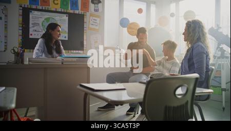 Mère et père regardant les résultats du test scolaire de leur fils pendant la soirée des parents. Enseignant et parents heureux de l'excellente performance académique et le comportement du garçon de l'école élémentaire. Ralenti. Banque D'Images