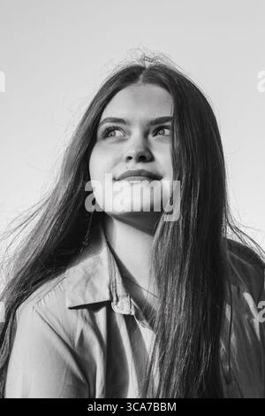 Photo en noir et blanc d'une femme aux cheveux longs levant les yeux Banque D'Images