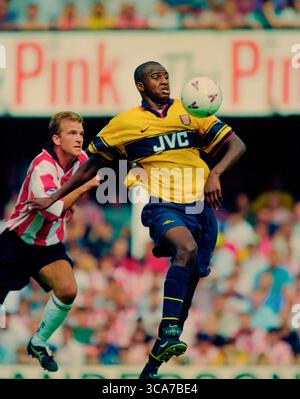 Patrick Vieira en action jouant pour Arsenal dans la saison 1998-99 dans le kit extérieur jaune JVC. Cette image est liée par les restrictions de Dataco sur la façon dont elle peut être utilisée. UTILISATION ÉDITORIALE UNIQUEMENT aucune utilisation avec des fichiers audio, vidéo, données, listes de présentoirs, logos de club/ligue ou services « live » non autorisés. Banque D'Images