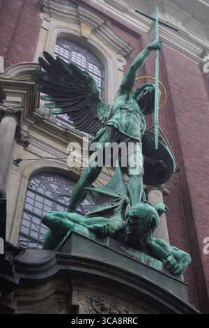 Gros plan vertical de la statue de bronze de l'Archange Michel conquérant le diable au-dessus du portail de l'église de Michel, Hambourg, Allemagne Banque D'Images