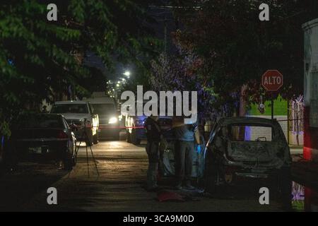 La police sonde une voiture incendiée liée à l'escalade des conflits de gangs à Ciudad Juarez. Banque D'Images