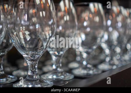 Nettoyez les verres à vin bien alignés sur un comptoir en bois pour le service après-vente. Banque D'Images