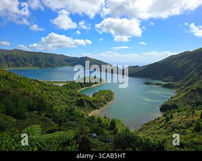 Vue sur Lagoa do Fogo, un lac de cratère volcanique situé sur l'île de São Miguel dans les Açores, Portugal, entouré de montagnes verdoyantes sous une partie Banque D'Images