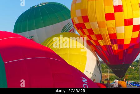 Quatre ballons d'air chaud colorés en cours de préparation pour le vol Banque D'Images