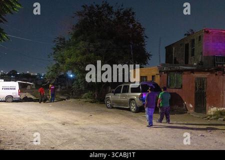Une équipe médico-légale enquête sur une scène de crime la nuit dans un quartier résidentiel de Ciudad Juarez, mettant en lumière les problèmes de violence urbaine. Banque D'Images