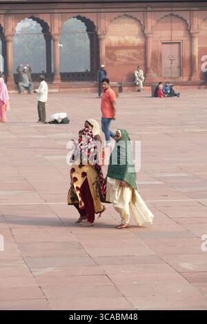 DELHI - 19 nov 2019 - des femmes musulmanes marchant pieds nus à travers l'intérieur grandiose de Jama Masjid, mosquée emblématique dans le centre historique du vieux Delhi Banque D'Images