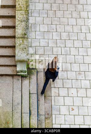 Une personne en costume noir descend un escalier. Banque D'Images