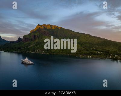Yacht de luxe ancré dans la baie de Cook au coucher du soleil, île de Moorea, Tahiti. Banque D'Images