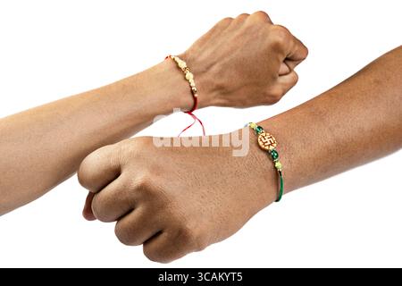 Mains humaines montrant des rakhis colorés au poignet, isolés sur un fond blanc, célébrant le lien de l'amour et de la protection. Concept du Raksha Banque D'Images