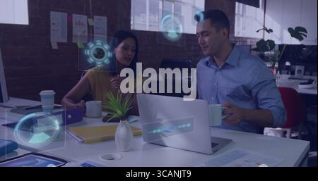 Collaborateurs en tenue professionnelle examinant les cartes au bureau, avec ordinateur portable et tasses Banque D'Images