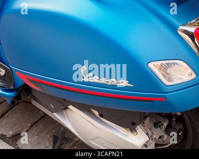 Cremona, Italie 4 août 2025 Vespa scooter bleu brillant sous la lumière du soleil, reposant sur un pavé vintage, mettant en valeur les styles italiens classiques Banque D'Images