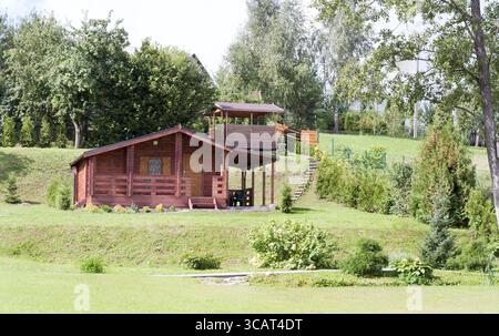 Pelouse verte et maison à colombages auto-faite sur une pente de colline, une journée ensoleillée d'été Banque D'Images