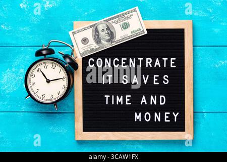 Concentré de devis commercial motivant et inspirant. Il économise du temps et de l'argent mots sur le tableau de lettre bleu avec un billet de cent dollars sur backgroun en bois Banque D'Images