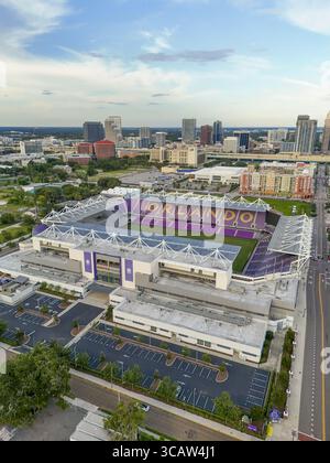 Orlando, États-Unis - 21 juillet 2025 : vue aérienne du stade Exploria baigné de soleil, ses sièges violets contrastent avec les gratte-ciel de la ville. Banque D'Images
