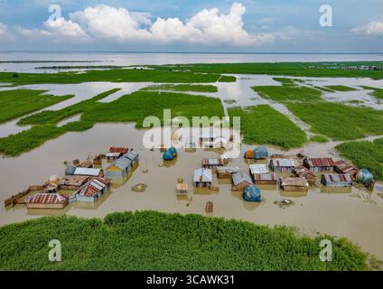 Sariakandi, Bangladesh - 15 juillet 2019 : vue aérienne de maisons immergées dans les eaux de crue, un tableau de résilience sombre dans le contexte d'une vaste étendue d'eau. Banque D'Images