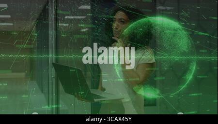 Analysant la femme dans la tenue de bureau interagissant avec l'affichage holographique dans le laboratoire, avec ordinateur portable et globe Banque D'Images