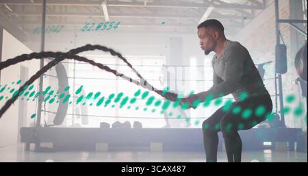 Cordes de combat accrocheuses homme travaillant dans un gymnase industriel, avec tapis roulant et poids, espace de copie Banque D'Images