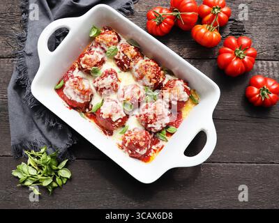 Casserole de boulettes de viande au fromage cuite avec sauce tomate sur fond en bois, vue de dessus Banque D'Images