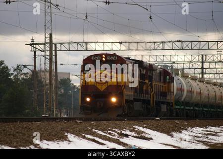 La locomotive diesel numéro 1574 des chemins de fer estoniens (EVR) mène une longue série de wagons-citernes à travers un paysage hivernal enneigé en Estonie le 27 janvier Banque D'Images