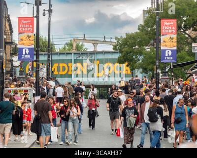 Une foule immense se promène sous l'emblématique pont ferroviaire « Camden Lock », un monument célèbre au cœur de Camden Market, Londres, Royaume-Uni. Banque D'Images