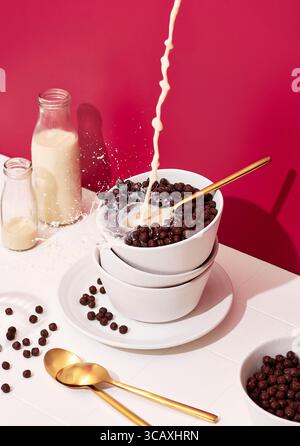 Verser le lait sur Choco Pops dans un bol Banque D'Images