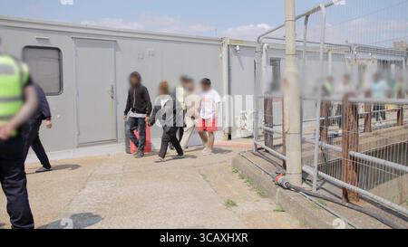 NOTE DE LA RÉDACTION - LES IMAGES SONT FLOUES À LA SOURCE. Capture d'écran tirée d'une vidéo publiée par le Home Office des premiers migrants de petits bateaux détenus dans le cadre du nouveau contrat « One In, One Out » du Royaume-Uni, à Western Jet Foil à Douvres, dans le Kent. Les migrants, qui ont été détenus le jour où le projet pilote a commencé à fonctionner, passent par les premières étapes du processus pilote de retour Royaume-Uni-France au cours des dernières 24 heures, y compris le traitement initial, les contrôles biométriques et de sécurité, et la réinstallation au Centre de renvoi de l'immigration pour attendre leur retour en France. Date de la photo : jeudi 7 août 2025. Banque D'Images